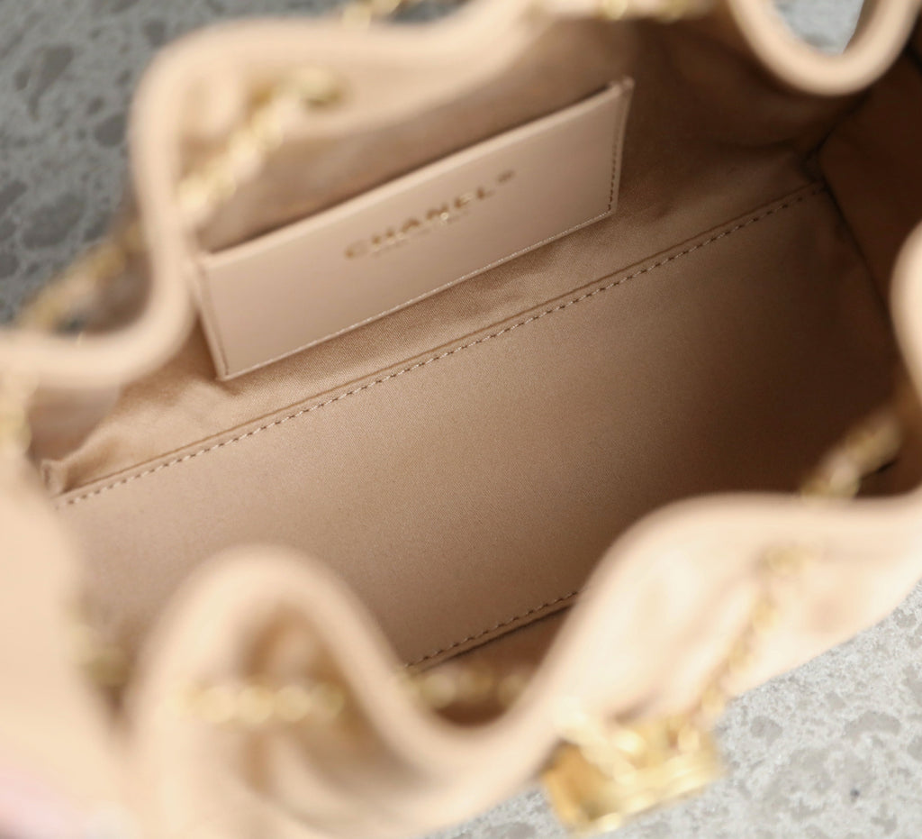 Chanel beige interior lining with stitched panel and gold-tone chain strap hardware.