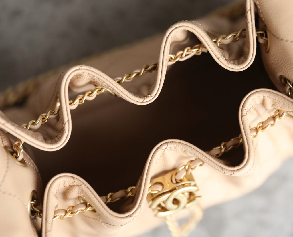 Chanel beige interior with gold-tone chain link straps along the bag opening.