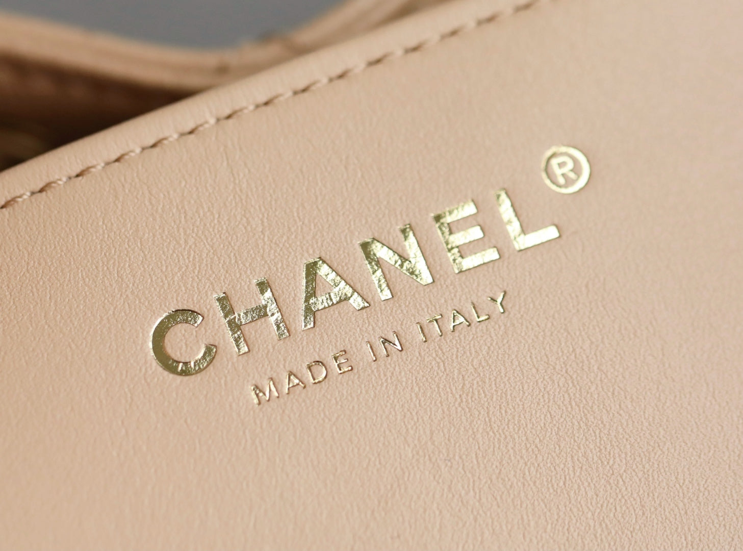 Chanel logo on beige leather, with 'MADE IN ITALY' text below.