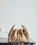 Chanel beige bucket bag with quilted pattern, gold hardware, and chain shoulder straps.
