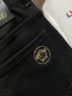 Black pants coin pocket with gold logo button and visible stitched panel seams