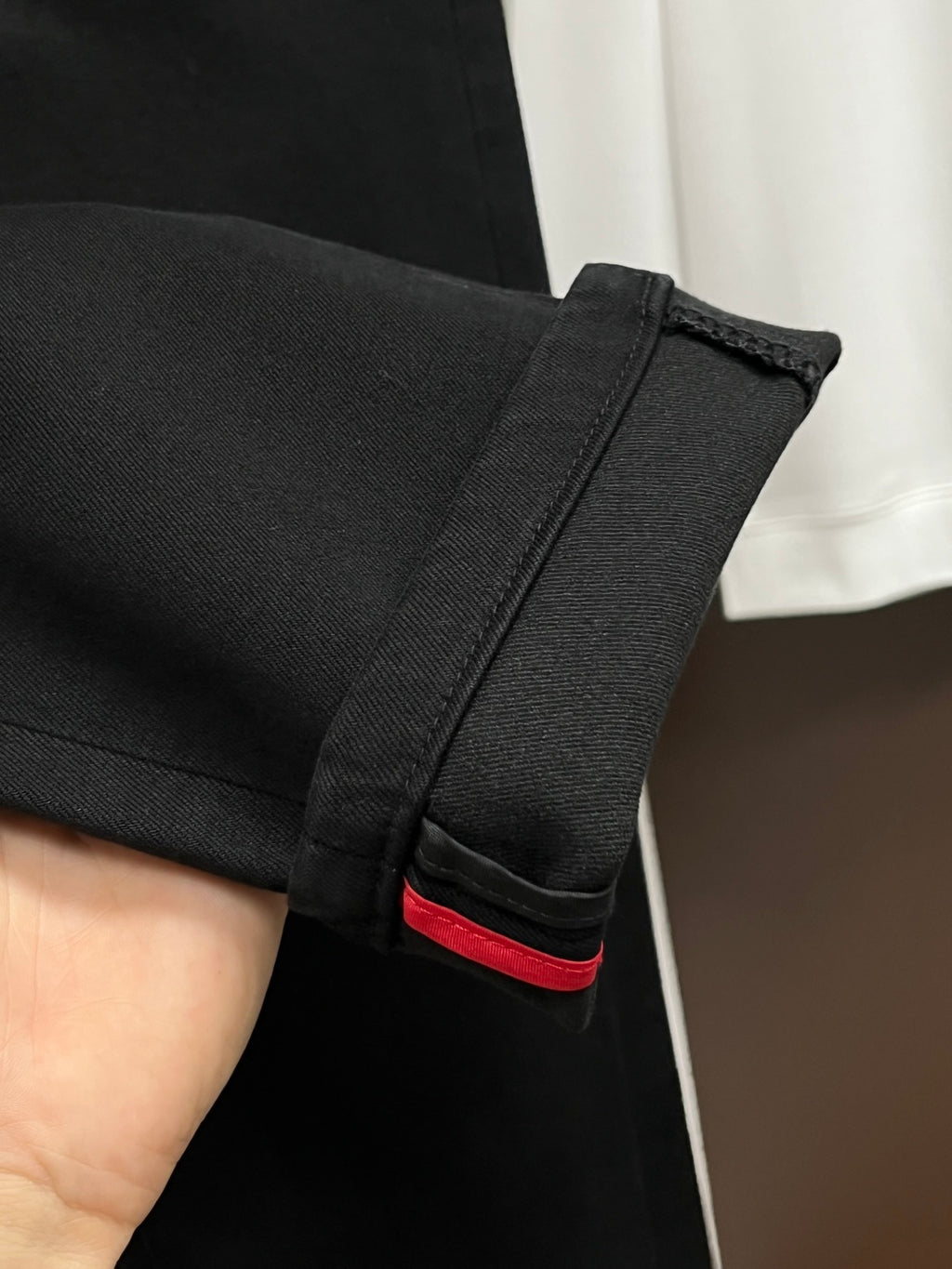 Black pants hem and interior waistband trim with red accent stripe