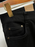 Black pants front pocket detail with gold button and inner panel stitching