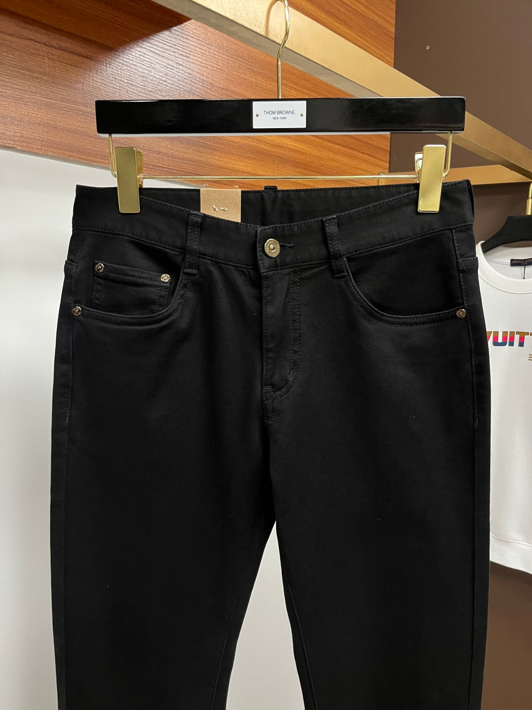 Black pants on hanger, close front with dual pockets and waist button