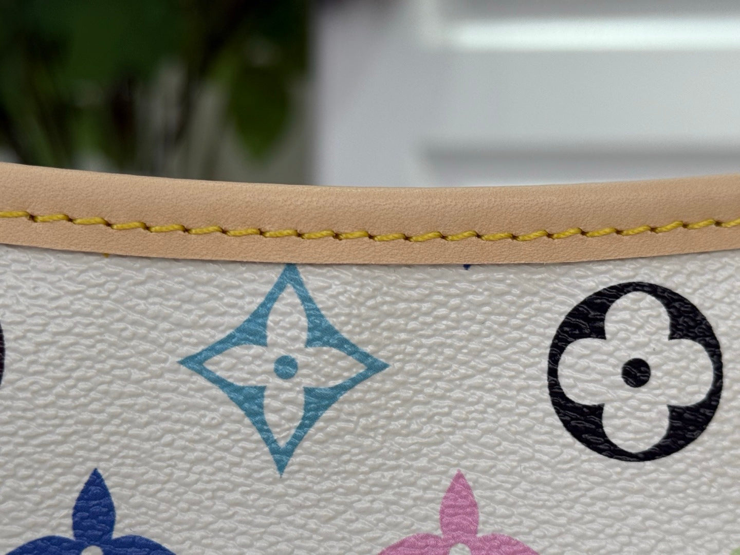 Close-up of multicolor monogram icons on white textured leather