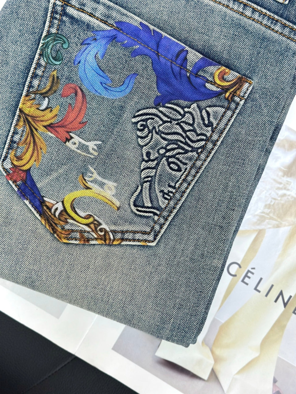 Embroidered denim jeans front pocket with colorful baroque-style graphic patch