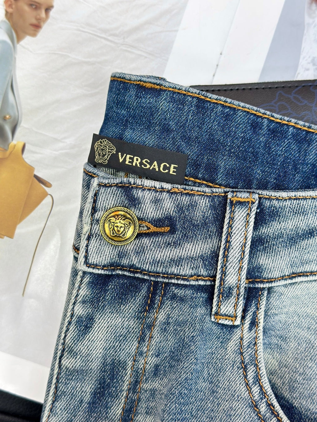 Versace denim jeans waistband with logo print and gold-tone button closure