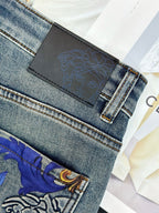 Denim jeans with black leather-look waistband patch and embossed ornamental pattern