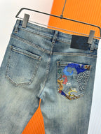 Light-wash denim jeans with front pockets and colorful graphic pocket detail