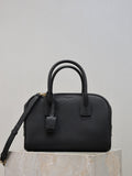 Black structured handbag with top handles, front strap detail, and crossbody strap
