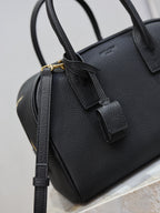 Black pebbled leather handbag with front strap tab and gold-tone hardware