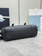 Prada handbag with dark leather front panel, top zip, padded structured shape.