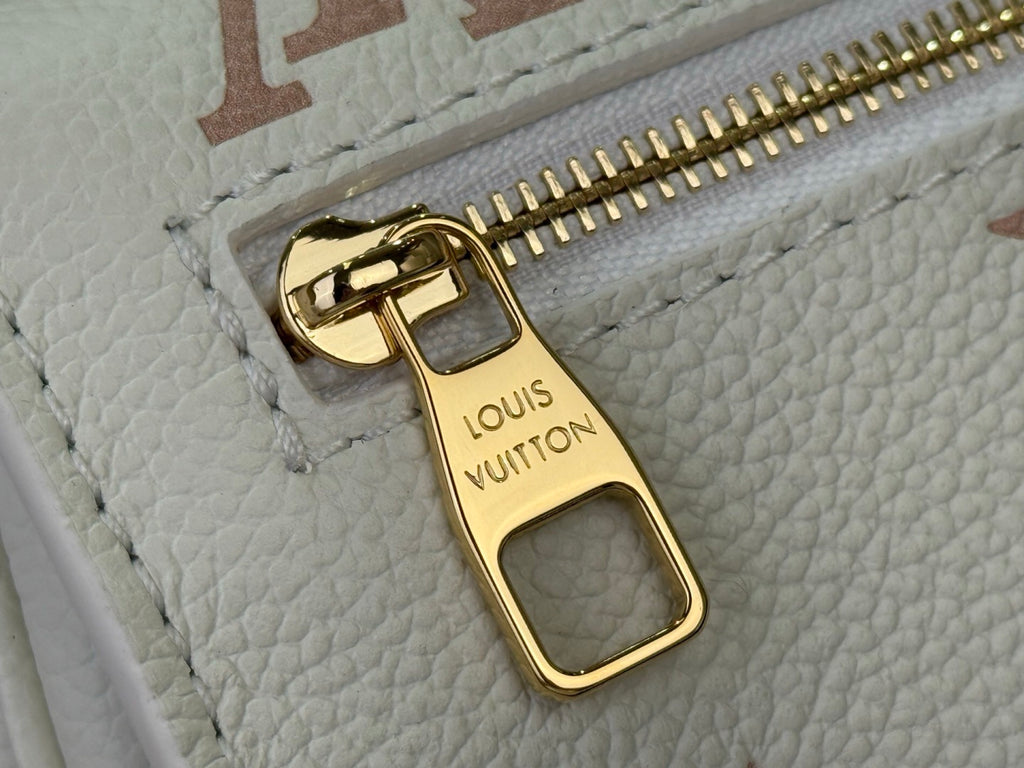 Louis Vuitton bag close-up of gold zipper pull and Louis Vuitton Paris label
