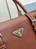 Brown Prada logo triangle plaque on leather handbag front