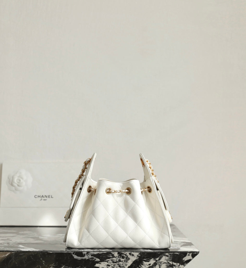Chanel white quilted handbag with gold chain handles on display