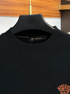 Black Versace knit sweater neckline with logo patch at the collar