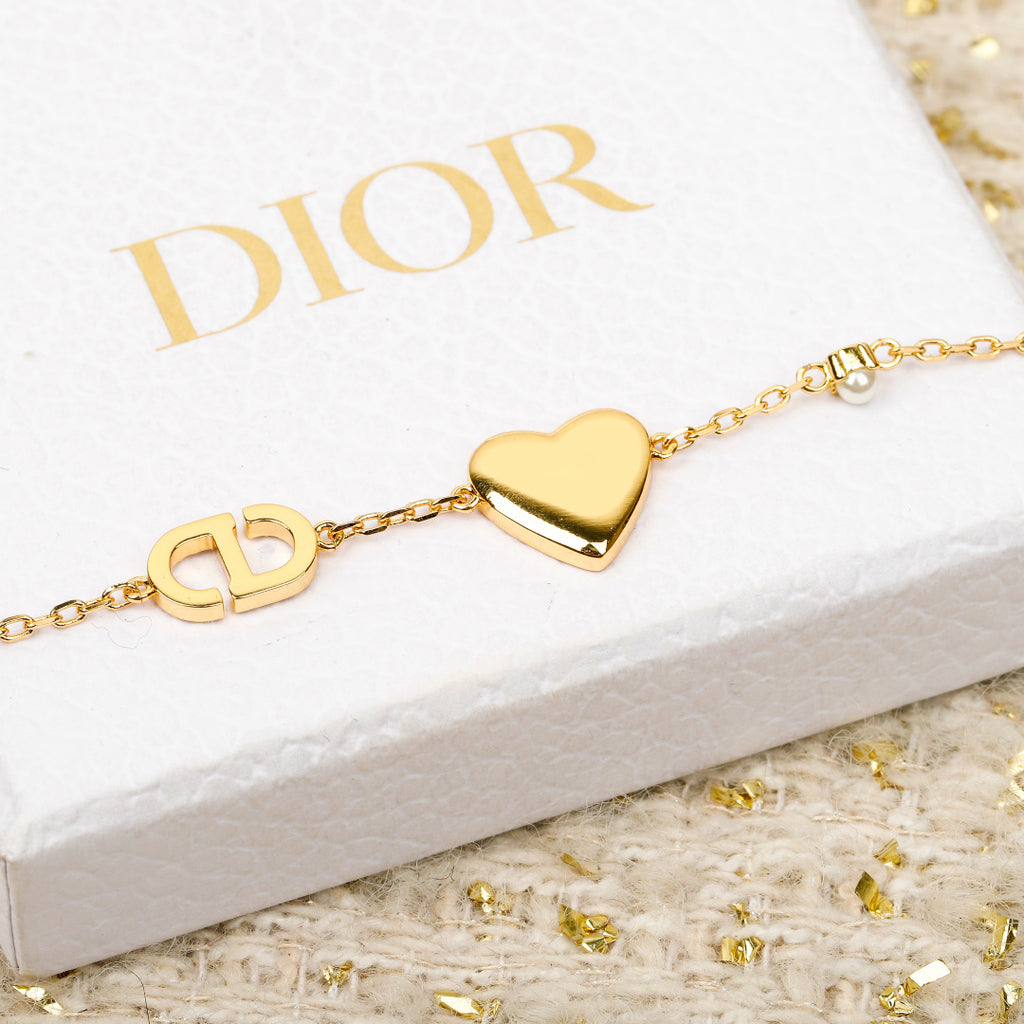 Gold-tone bracelet with pink heart pendant, small gold link charms