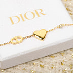 Gold-tone bracelet with pink heart pendant, small gold link charms