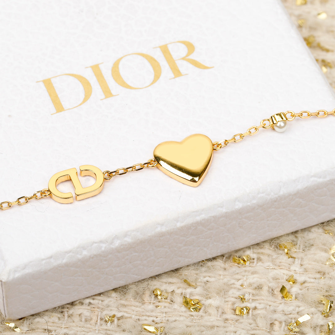 Gold-tone bracelet with pink heart pendant, small gold link charms