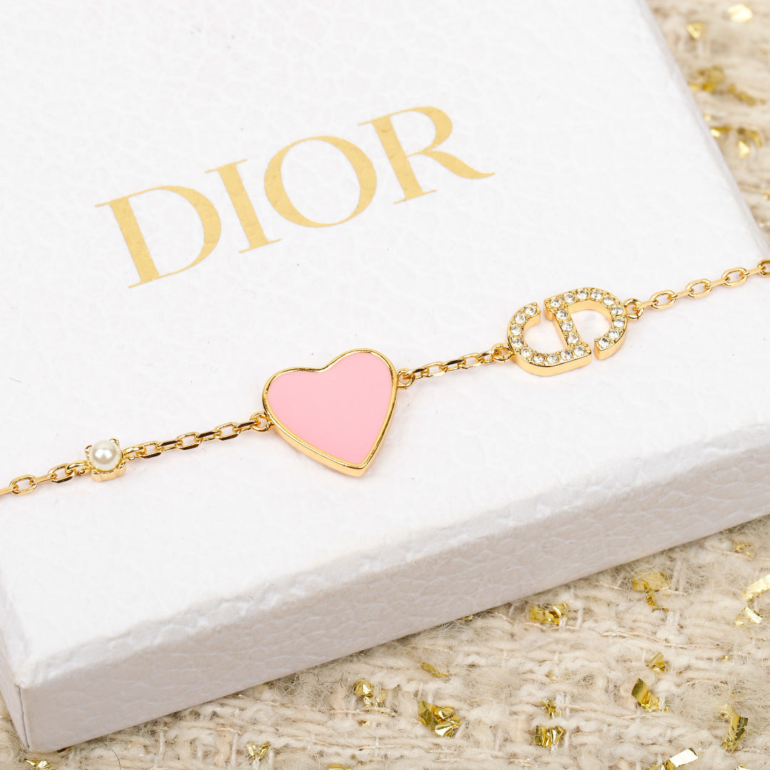 Gold-tone bracelet with pink heart charm and rhinestone letter accents