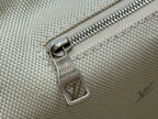 Beige Louis Vuitton bag zipper pull on textured canvas with monogram marks