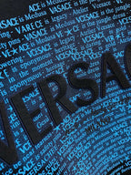 Close-up of blue Versace Medusa lettering print on black sweatshirt front.