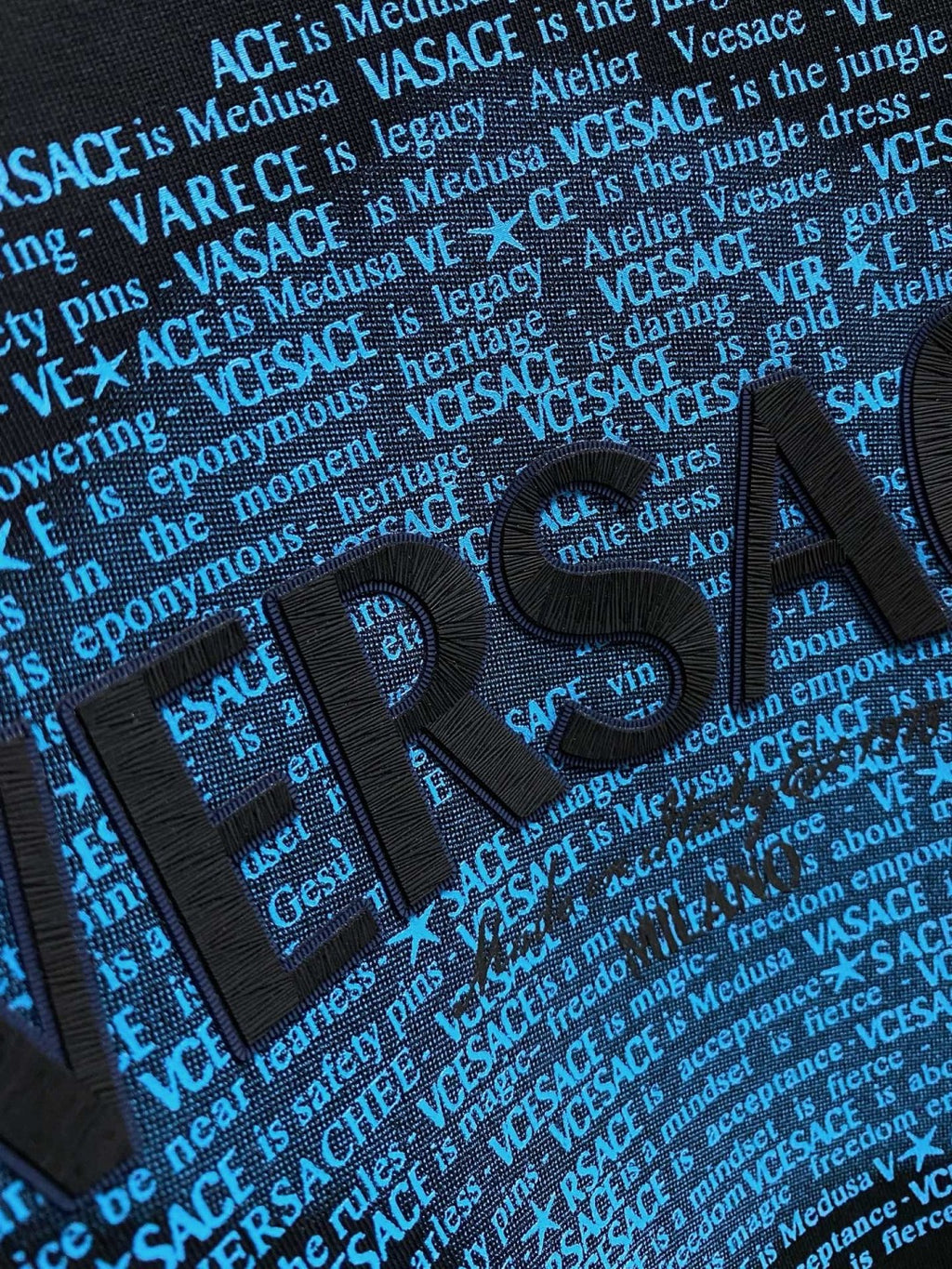 Versace black sweatshirt front close-up with bold blue VERSACE text graphic