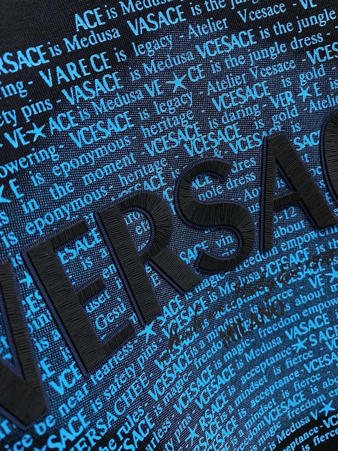 Versace black sweatshirt front close-up with bold blue VERSACE text graphic