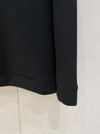 Black crewneck sweatshirt hem and cuffs shown; solid knit with no visible graphics.