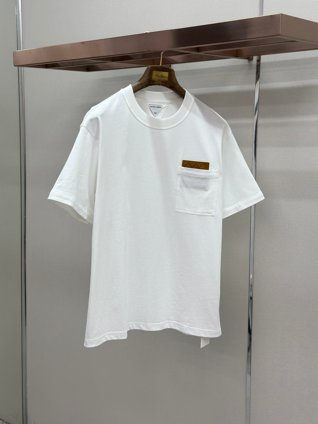 Off-white crew-neck T-shirt with chest pocket and small logo patch