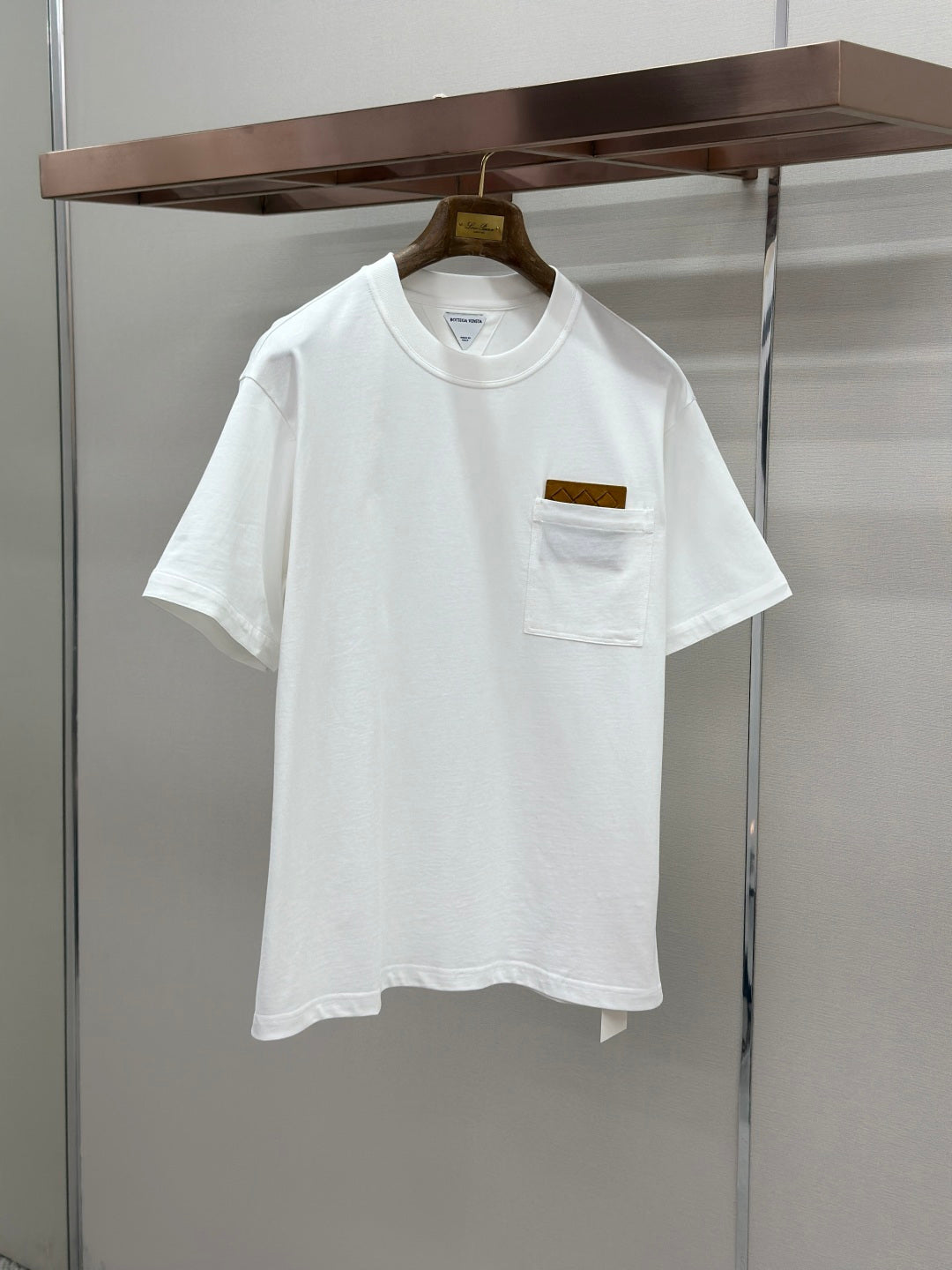 Off-white crew-neck T-shirt with chest pocket and small logo patch
