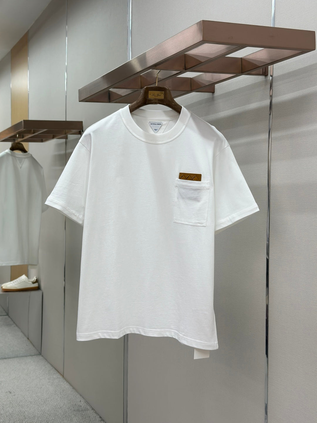 Off-white crew-neck T-shirt with chest pocket and small logo patch