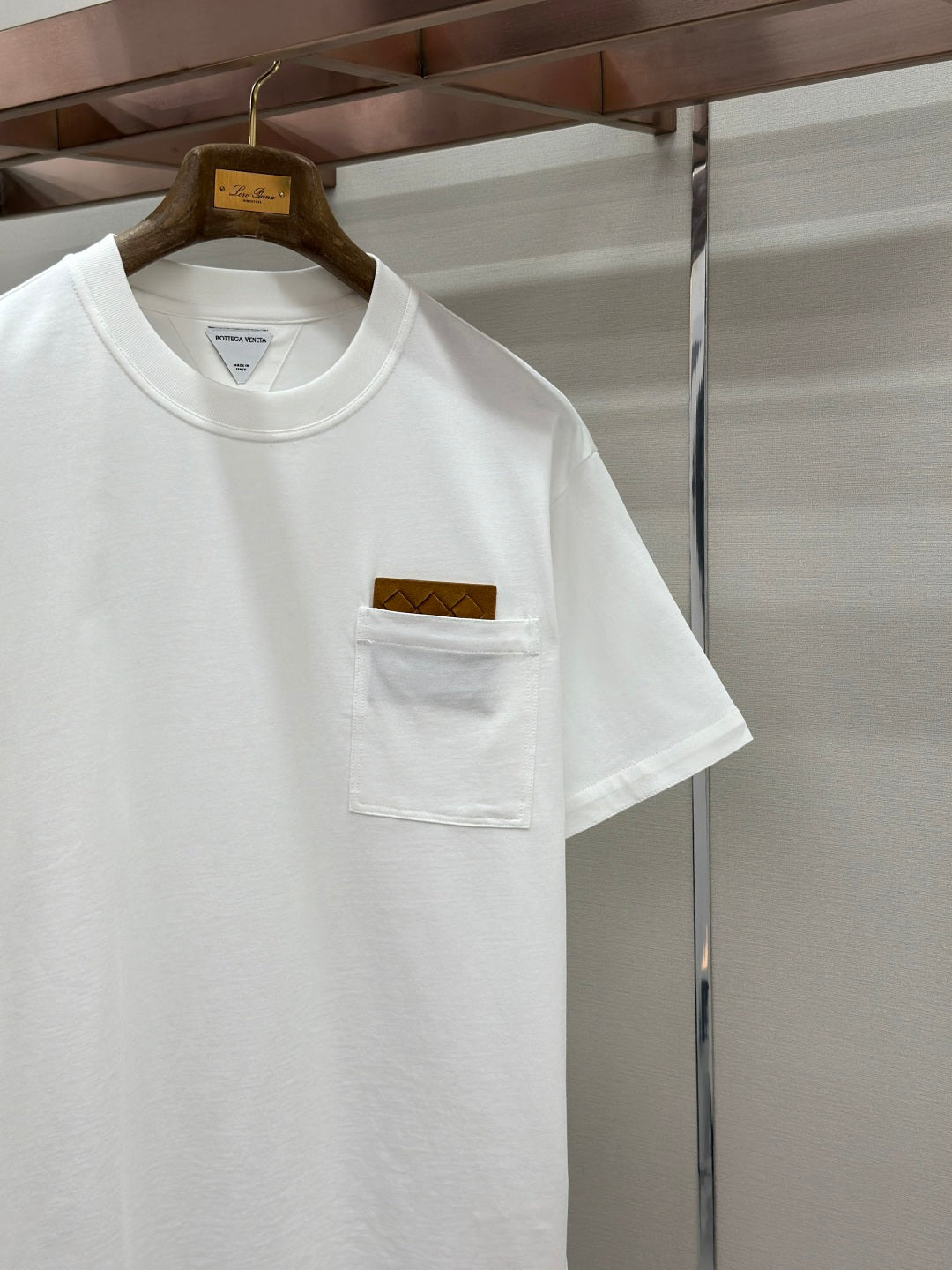 Off-white crew-neck T-shirt with chest pocket and logo patch