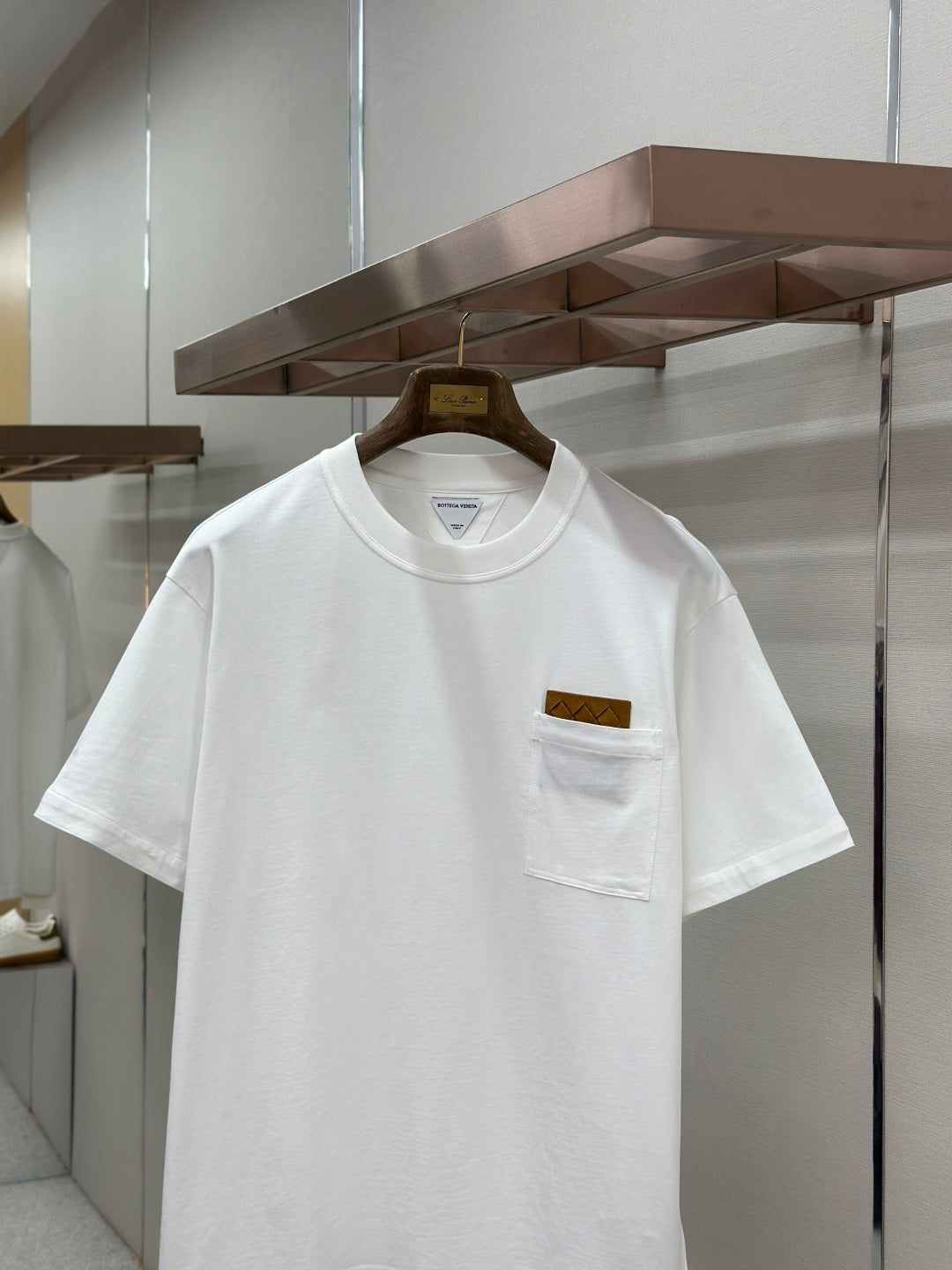 Off-white crew-neck T-shirt close-up at logo chest pocket