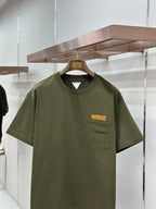 Olive green crew-neck T-shirt with chest pocket and rectangular logo patch