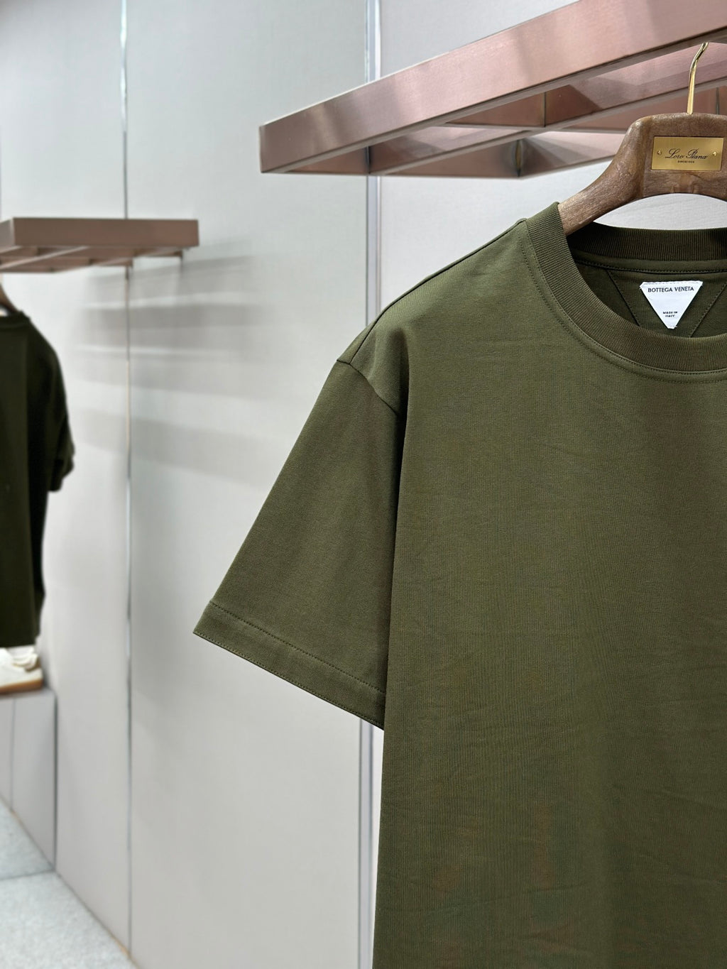 Olive green crew-neck T-shirt close-up of chest pocket and logo patch