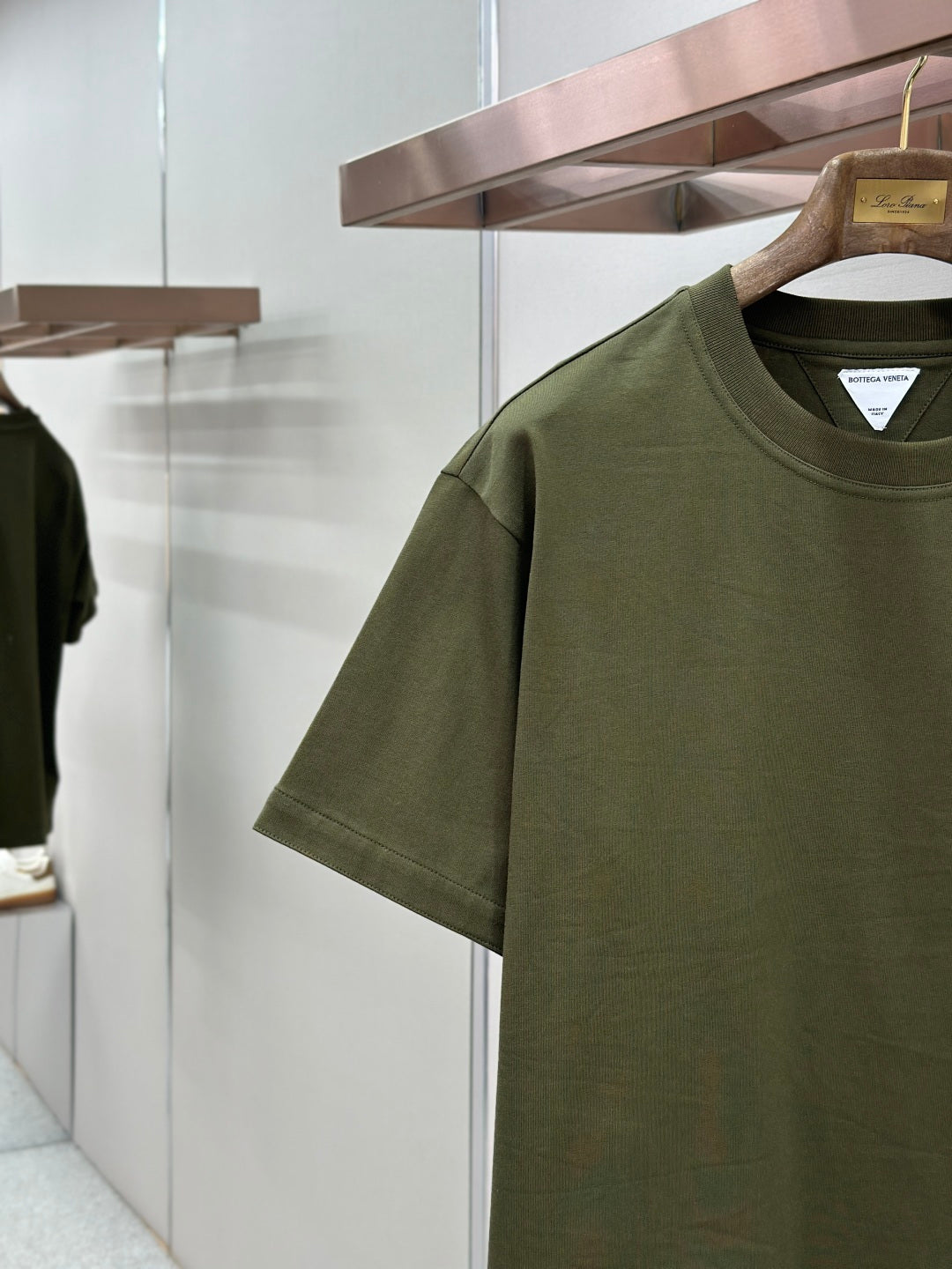 Olive green crew-neck T-shirt close-up of chest pocket and logo patch