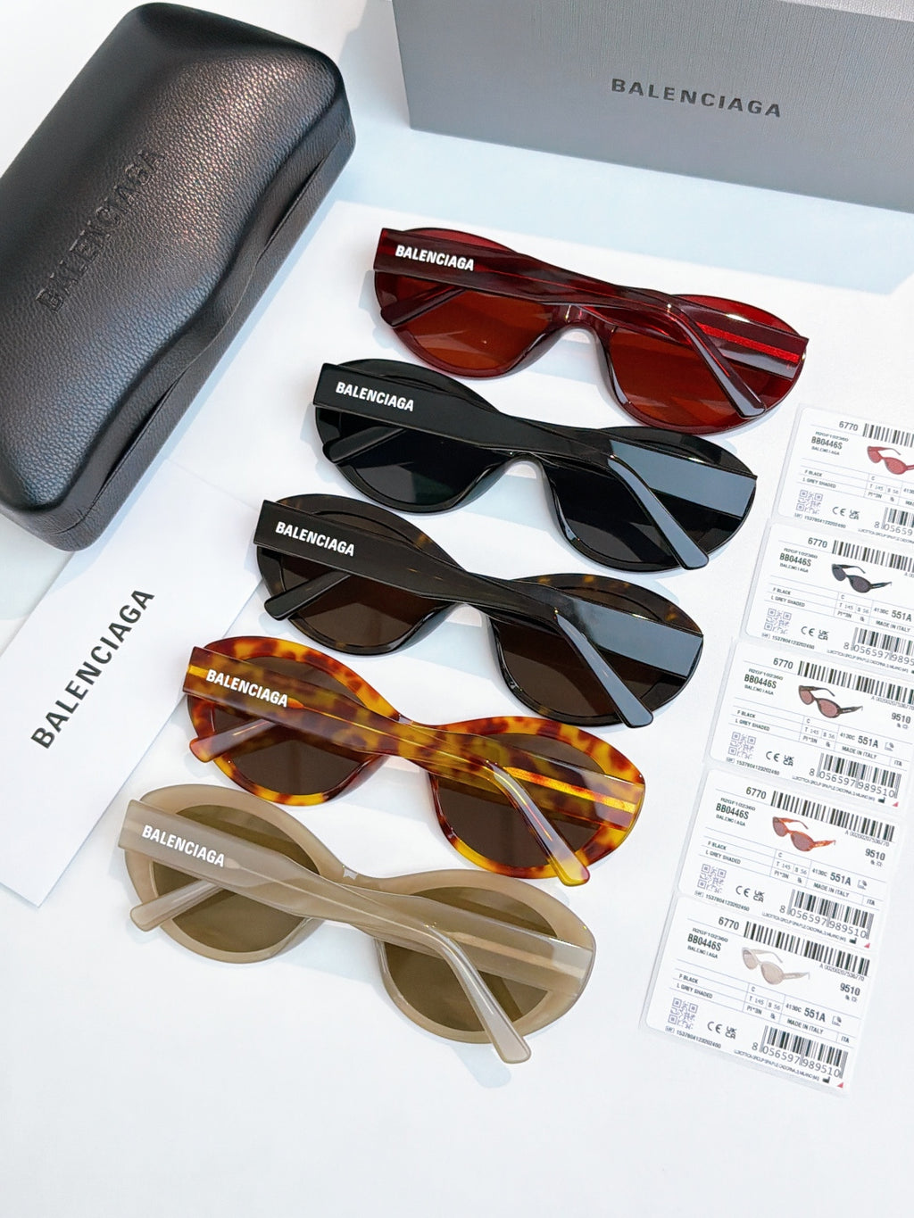 Sunglasses assortment with red, black, tortoise, and beige frames and tinted lenses.