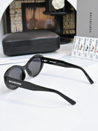 Black round sunglasses shown from the side with dark lenses and full-rim frame.