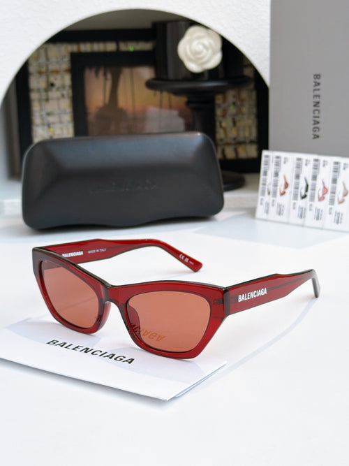 Balenciaga cat-eye sunglasses with red frames and warm brown tinted lenses