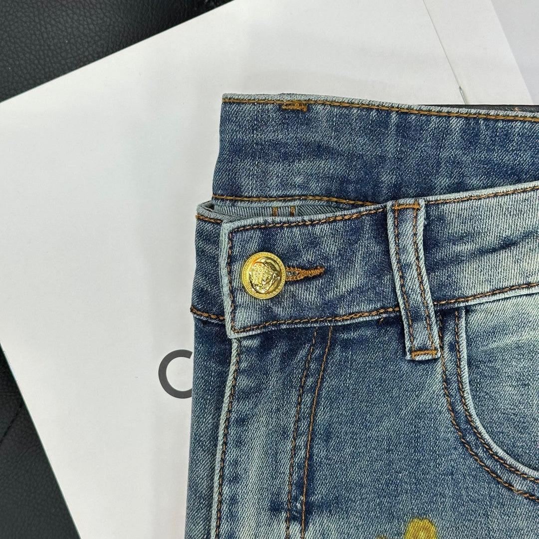 Blue denim jeans waistband with gold button and belt loops, front view close-up.