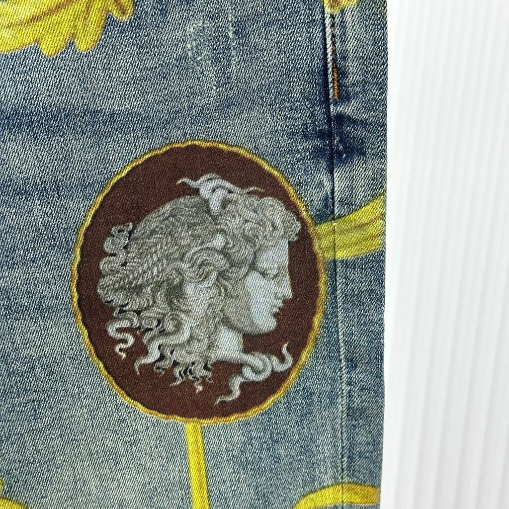 Versace jeans detail: brown medallion with gray face, outlined in gold on denim