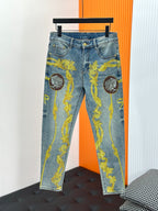 Blue denim jeans with bold gold baroque print and cameo medallions on the legs.