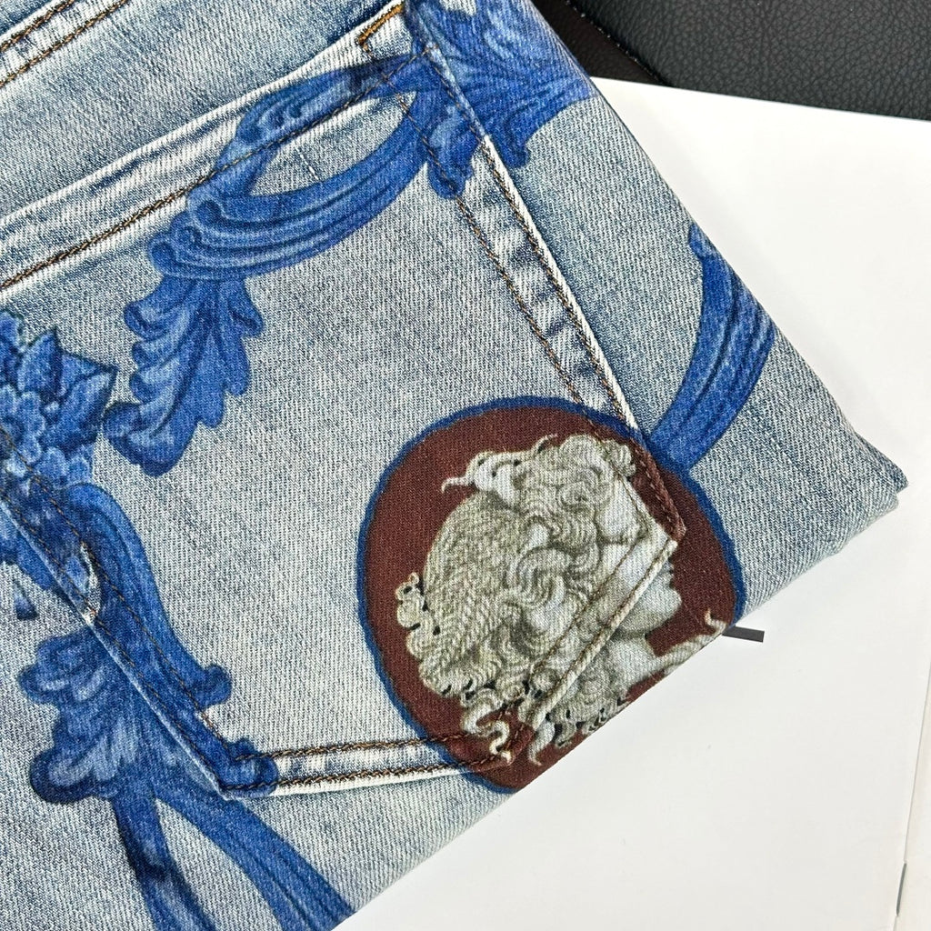 Versace denim jeans close-up of blue baroque print and lion medallion on pocket