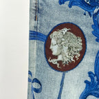 Versace denim jeans close-up of blue floral scrolls and round lion medallion