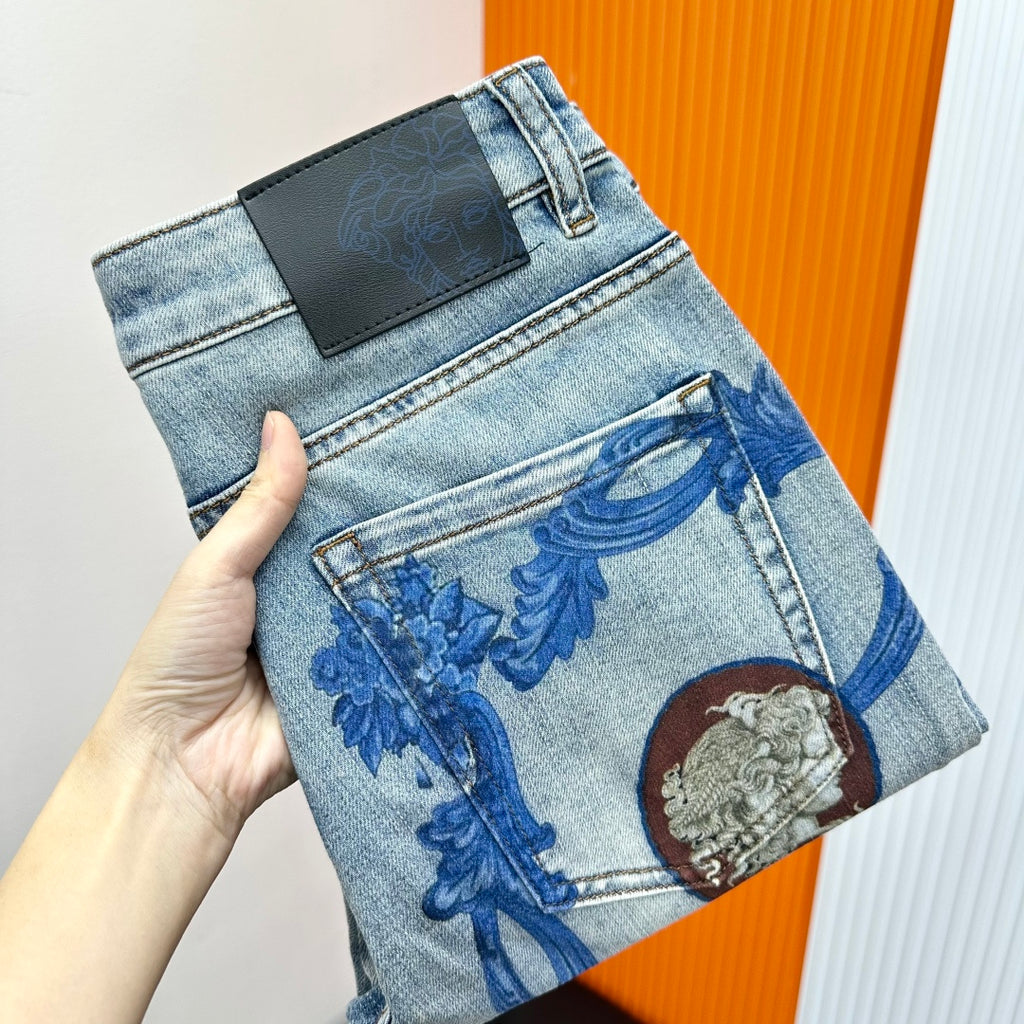 Light-wash denim jeans with blue baroque print and medallion accents