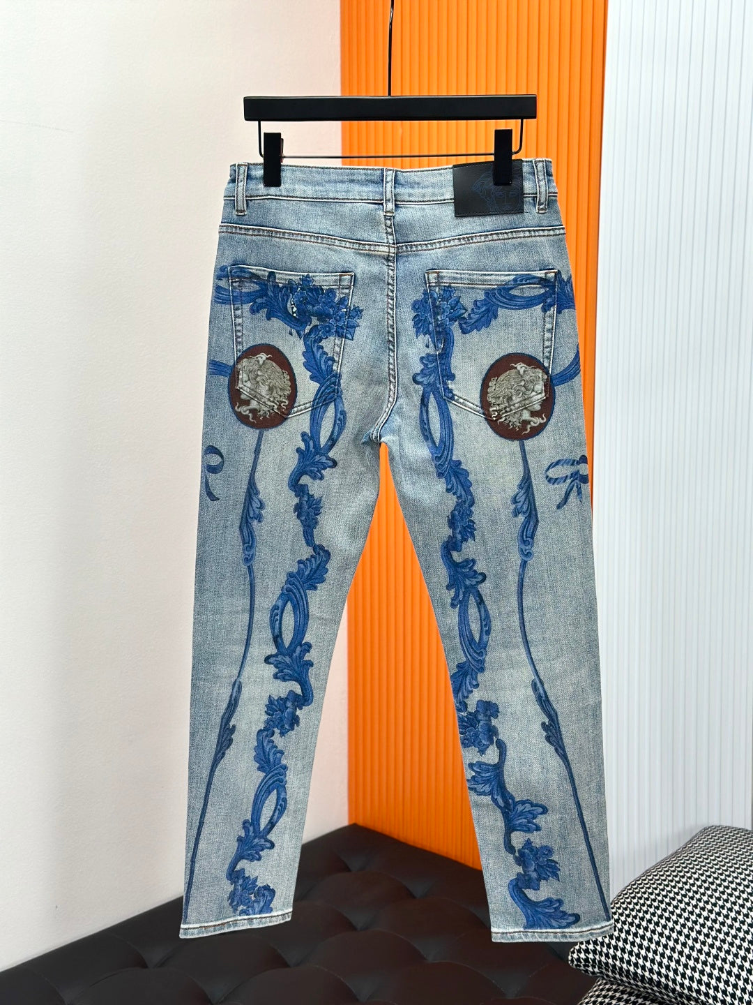 Blue baroque-print denim jeans on display with button fly and side pockets