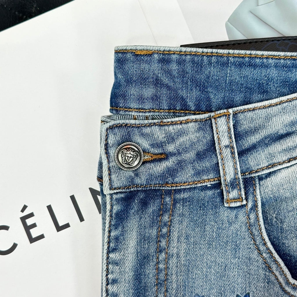 Denim jeans close-up: metal button and woven logo patch on waistband