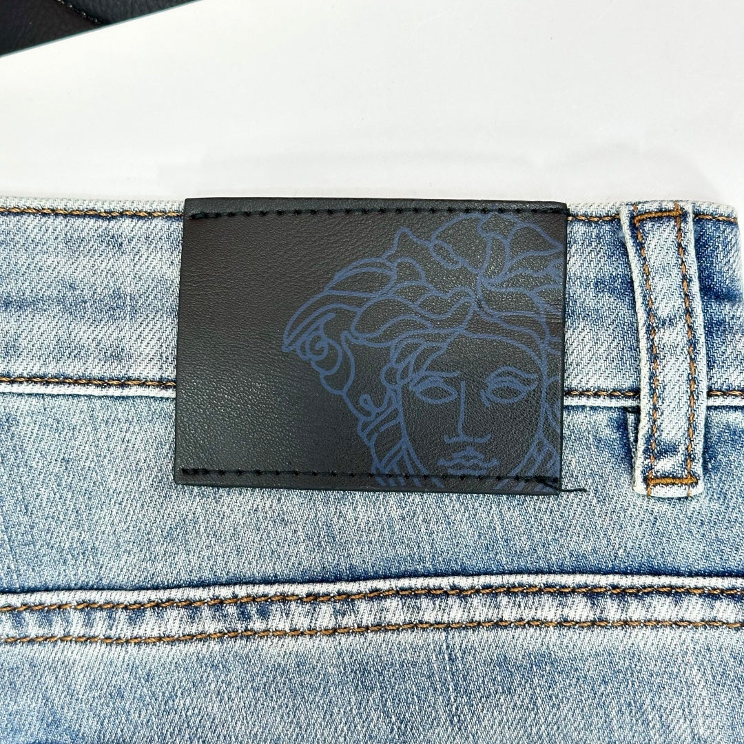 Versace leather-look logo patch on light-wash denim jeans waistband