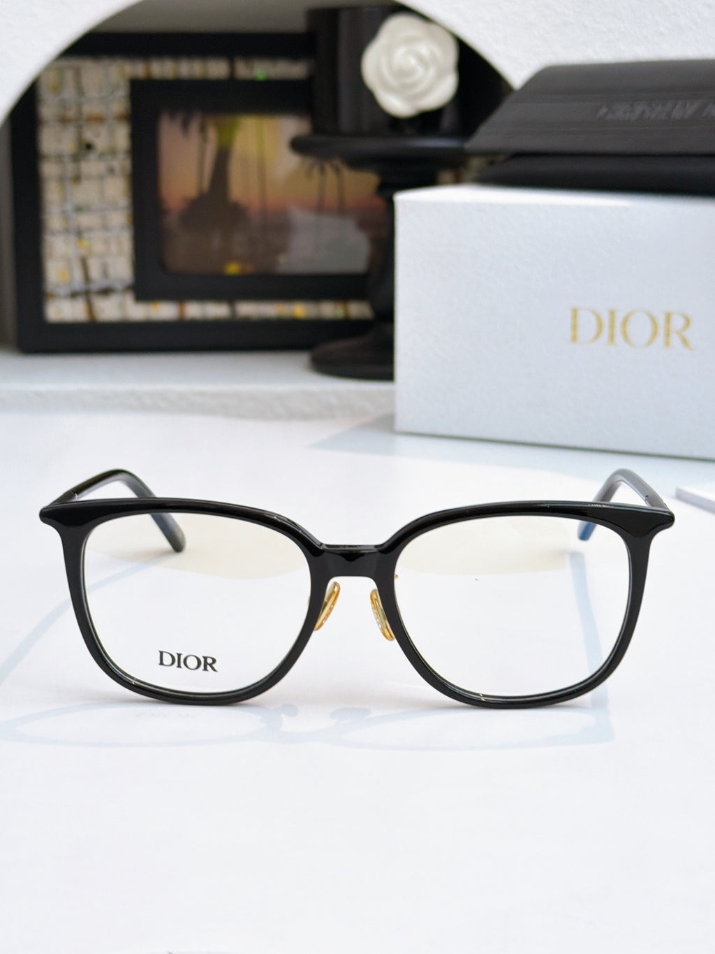 Black full-rim eyeglasses with Dior logo on lenses and thin metal hinges